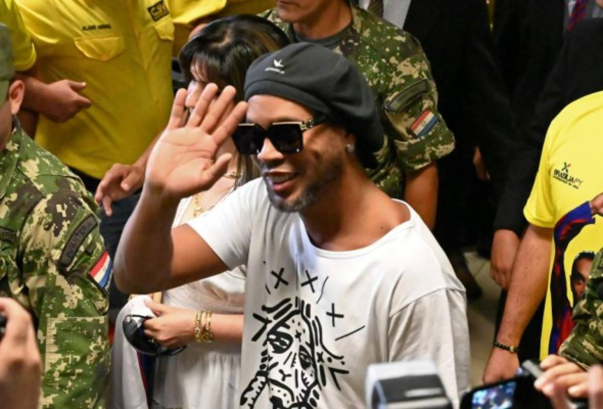 Brazilian ex-football star Ronaldinho Gaucho waves upon arriving at Silvio Pettirossi International Airport in Luque, near Asuncion, on March 4, 2020. - Ronaldinho arrived in Paraguay to present his latest book 'Genio en la Vida' and a health programme for girls and boys. (Photo by Norberto DUARTE / AFP)