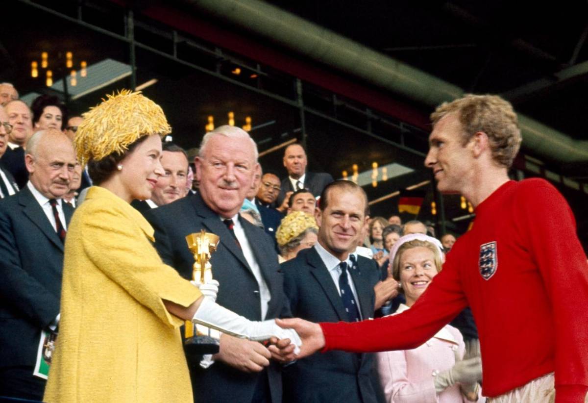 La Reina Isabal entregándole el trofeo de la Copa del Mundo a Booby Moore en 1966.