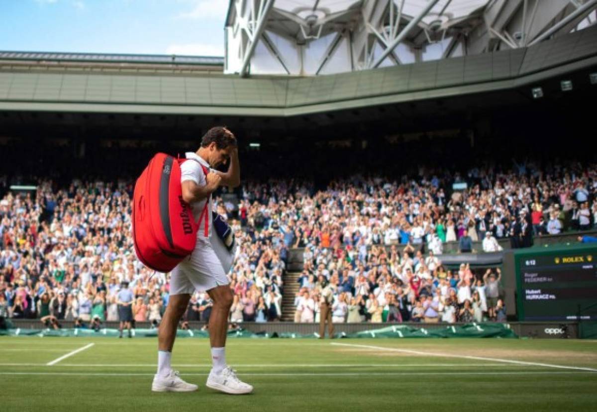 Switzerland's Roger Federer leaves the court after losing to Poland's Hubert Hurkacz during their men's quarter-finals match on the ninth day of the 2021 Wimbledon Championships at The All England Tennis Club in Wimbledon, southwest London, on July 7, 2021. - Hurkacz won the match. (Photo by AELTC/Edward Whitaker / POOL / AFP) / RESTRICTED TO EDITORIAL USE