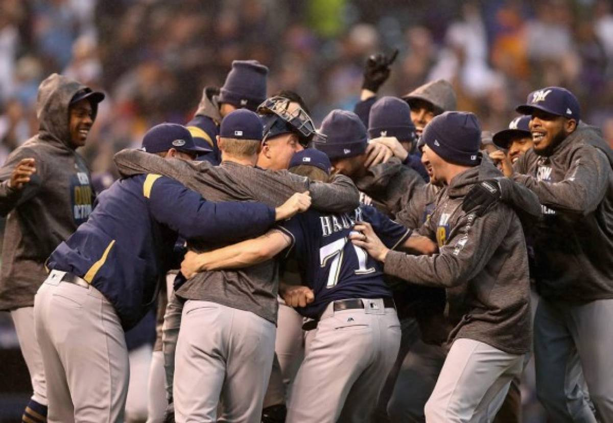 DENVER, CO - OCTOBER 07: Josh Hader #71 of the Milwaukee Brewers is mobbed by teammates after winning Game Three of the National League Division Series over the Colorado Rockies at Coors Field on October 7, 2018 in Denver, Colorado. The Brewers won the game 6-0 and the the series 3-0. Matthew Stockman/Getty Images/AFP