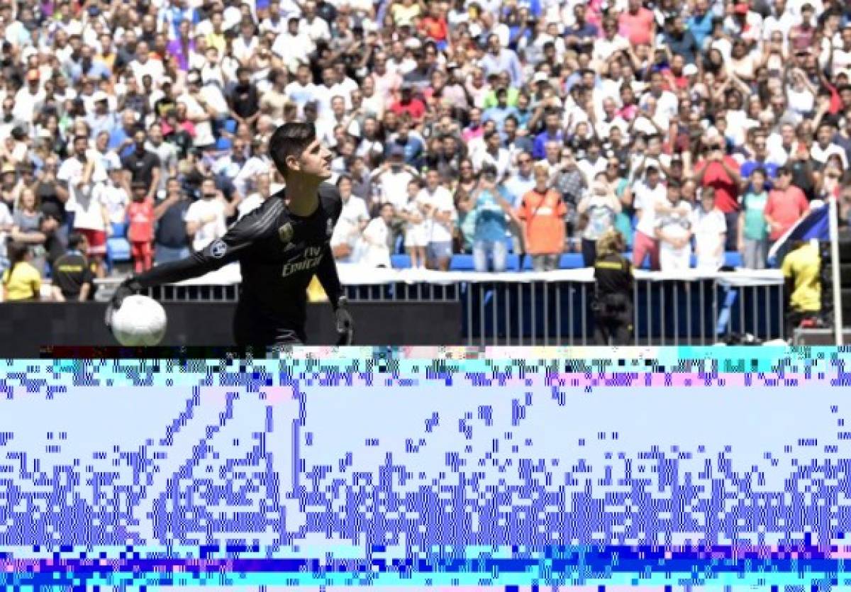 Belgian goalkeeper Thibaut Courtois throws balls to spectators during his presentation as new player of Real Madrid football team, at the Santiago Bernabeu stadium in Madrid on August 9, 2018.Belgian international goalkeeper Thibaut Courtois will play the next six seasons at Real Madrid after confirming his transfer from Chelsea, while the white team has given the Croatian player Mateo Kovacic for a season to the English club. / AFP PHOTO / JAVIER SORIANO