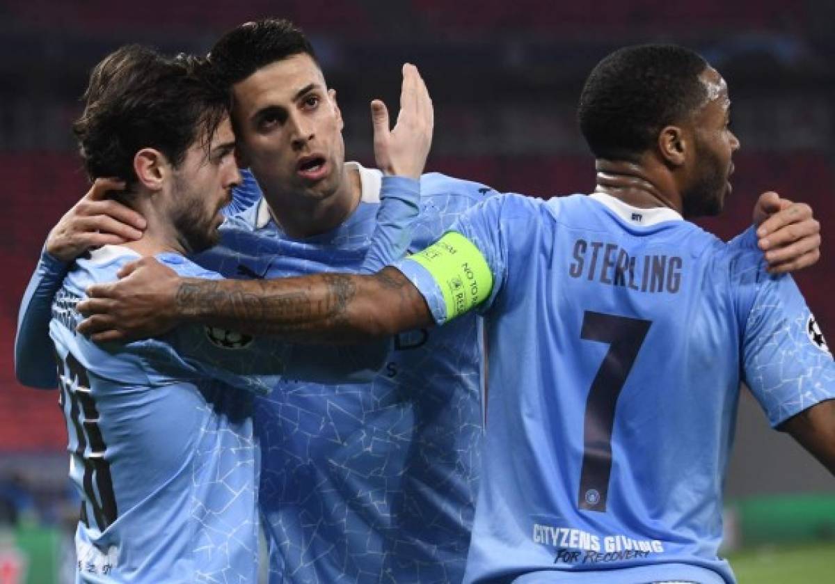 Manchester City's Portuguese midfielder Bernardo Silva (L) celebrates with Manchester City's Portuguese defender Joao Cancelo (C) and Manchester City's English midfielder Raheem Sterling scoring his team's first goal during the UEFA Champions League, last 16, 1st-leg football match Borussia Moenchengladbach v Manchester City at the Puskas Arena in Budapest on February 24, 2021. (Photo by Attila KISBENEDEK / AFP)