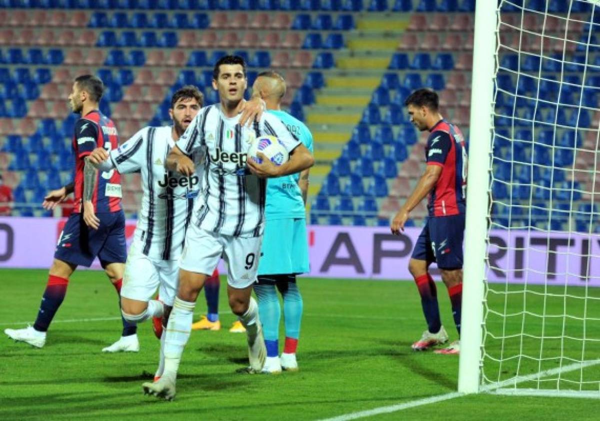 Juventus Spanish forward Alvaro Morata (C) celebrates with teammates after scoring a goal during the Italian Serie A football match Crotone vs Juventus at the Ezio Scida Stadium in Crotone on October 17, 2020. (Photo by Giovanni ISOLINO / AFP)