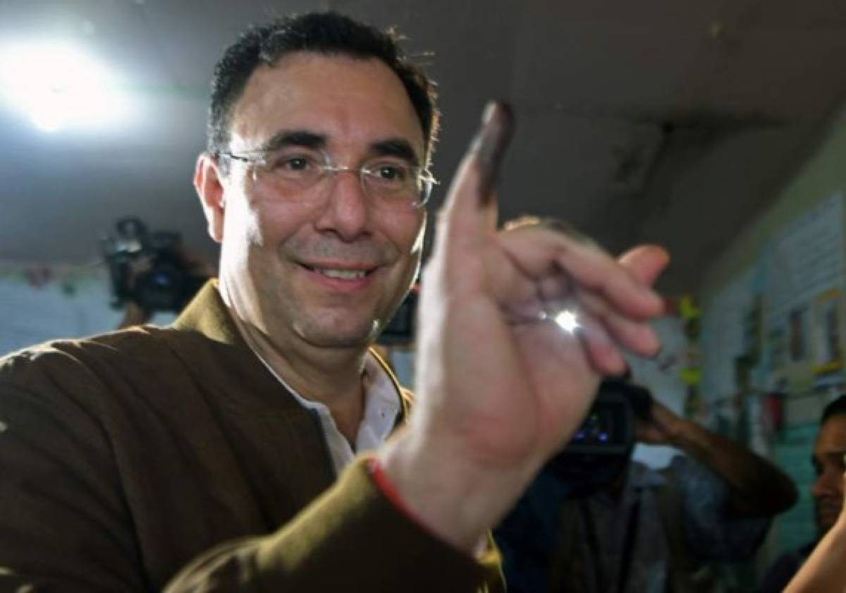 The presidential candidate of the opposition Liberal Party Luis Zelaya, shows hir ink-stained finger after casting his vote at a polling station in Santa Lucia municipality, 11 kilometres east of Tegucigalpa, during the general election on November 26, 2017.Honduras' six million voters are to cast ballots in a controversial election Sunday in which President Juan Orlando Hernandez is seeking a second mandate despite a constitutional one-term limit. This small country is at the heart of Central America's 'triangle of death,' an area plagued by gangs and poverty. / AFP PHOTO / ORLANDO SIERRA