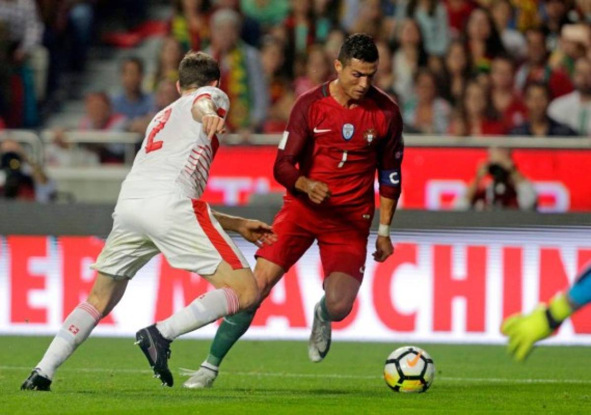 Portugals forward Cristiano Ronaldo (R) vies with and Swiss defender Stephan Lichtsteiner during the FIFA World Cup 2018 Group B qualifier football match between Portugal and Switzerland at the Luz Stadium in Lisbon on October 10, 2017. / AFP PHOTO / JOSE MANUEL RIBEIRO