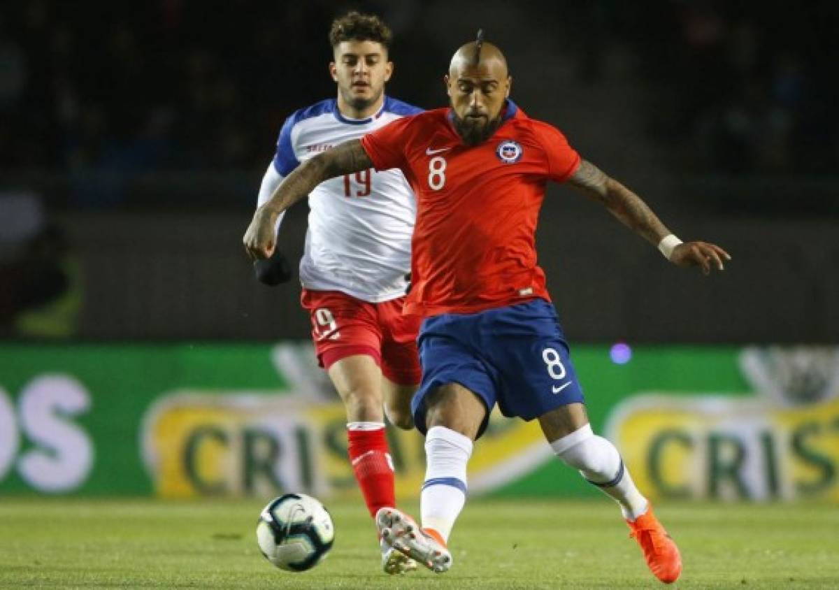 In this photo released by Photosport via Aton Chile's player Arturo Vidal (R) battles for the ball with Sheeven Saba of Haiti during a friendly football match at the La Portada Stadium in La Serena, Chile. (Photo by ANDRES PINA / Photosport Chile / AFP) / Chile OUT / RESTRICTED TO EDITORIAL USE - MANDATORY CREDIT 'AFP PHOTO / ATON / PHOTOSPORT / ANDRES PINA' - NO MARKETING NO ADVERTISING CAMPAIGNS - DISTRIBUTED AS A SERVICE TO CLIENTS
