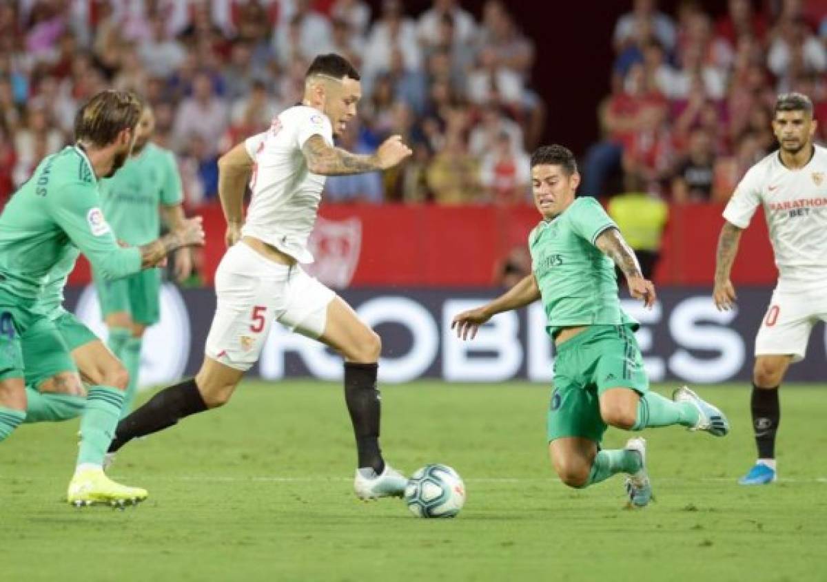 Sevilla's Argentinian midfielder Lucas Ocampos (L) vies with Real Madrid's Colombian midfielder James Rodriguez during the Spanish league football match between Sevilla FC and Real Madrid CF at the Ramon Sanchez Pizjuan stadium in Seville on September 22, 2019. (Photo by CRISTINA QUICLER / AFP)