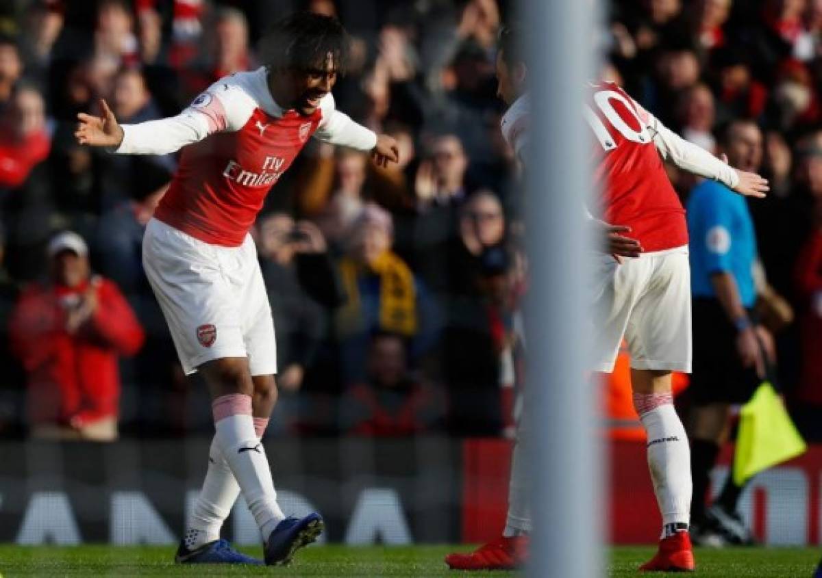 Arsenal's Nigerian striker Alex Iwobi (L) celebrates with Arsenal's German midfielder Mesut Ozil (R) after scoring their third goal during the English Premier League football match between Arsenal and Burnley at the Emirates Stadium in London on December 22, 2018. - Arsenal won the game 3-1. (Photo by Ian KINGTON / AFP) / RESTRICTED TO EDITORIAL USE. No use with unauthorized audio, video, data, fixture lists, club/league logos or 'live' services. Online in-match use limited to 120 images. An additional 40 images may be used in extra time. No video emulation. Social media in-match use limited to 120 images. An additional 40 images may be used in extra time. No use in betting publications, games or single club/league/player publications. /