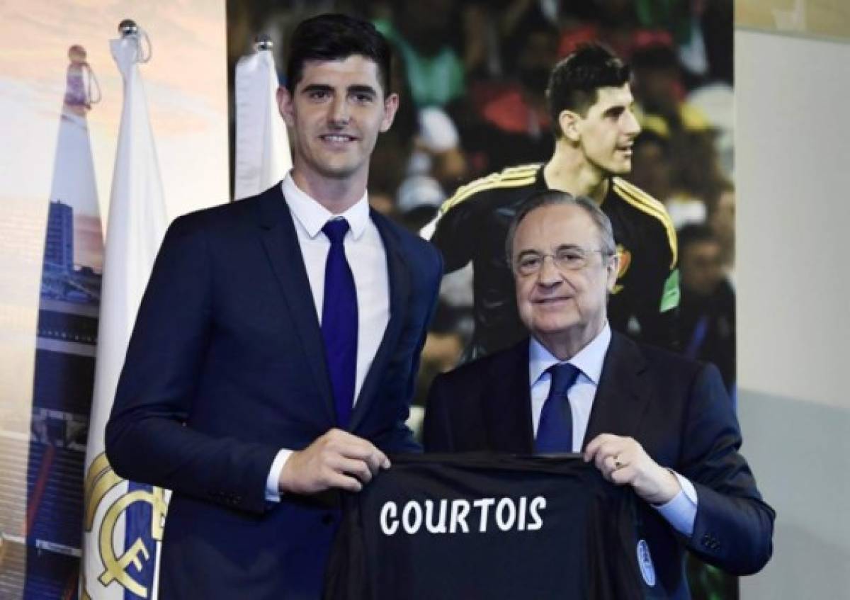 Belgian goalkeeper Thibaut Courtois (L) holds his new jersey with the president of Real Madrid, Florentino Perez during his presentation as new player of the Spanish football team, in Madrid on August 9, 2018.Belgian international goalkeeper Thibaut Courtois will play the next six seasons at Real Madrid after confirming his transfer from Chelsea, while the white team has given the Croatian player Mateo Kovacic for a season to the English club. / AFP PHOTO / JAVIER SORIANO