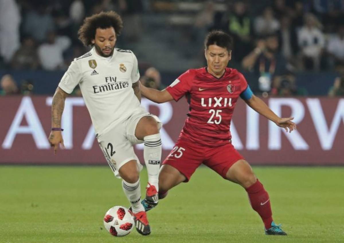 Real Madrid's Brazilian defender Marcelo (L) vies for the ball with Kashima Antler's midfielder Yasushi Endo during the semi final football match of the FIFA Club World Cup 2018 tournament between Japan's Kashima Antlers and Spain's Real Madrid at the Zayed Sports City Stadium in Abu Dhabi, the capital of the United Arab Emirates, on December 19, 2018. (Photo by KARIM SAHIB / AFP)