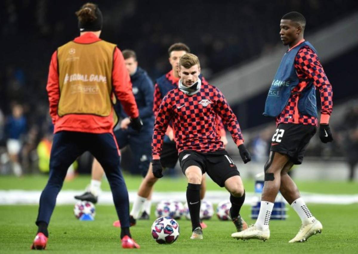RB Leipzig's German striker Timo Werner (C) and RB Leipzig's French defender Nordi Mukiele (R) warm up ahead of the UEFA Champions League round of 16 first Leg football match between Tottenham Hotspur and RB Leipzig at the Tottenham Hotspur Stadium in north London, on February 19, 2020. (Photo by Glyn KIRK / IKIMAGES / AFP)