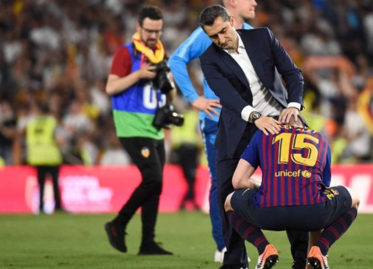 Barcelona's Spanish coach Ernesto Valverde conforts Barcelona's French defender Clement Lenglet at the end of the 2019 Spanish Copa del Rey (King's Cup) final football match between Barcelona and Valencia on May 25, 2019 at the Benito Villamarin stadium in Sevilla. - Barcelona wanted a trophy to ease their Champions League heartache but instead fell to another shock defeat as Valencia pulled off a thrilling 2-1 victory today to win the Copa del Rey. (Photo by JOSE JORDAN / AFP)