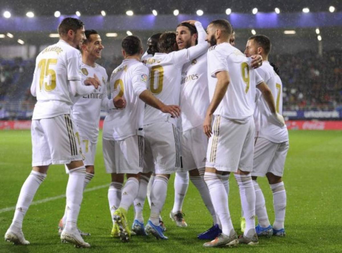 Real Madrid's plsyers celebrate after Real Madrid's French forward Karim Benzema scored a goal during the Spanish league football match between SD Eibar and Real Madrid CF at the Ipurua stadium in Eibar on November 9, 2019. (Photo by ANDER GILLENEA / AFP)