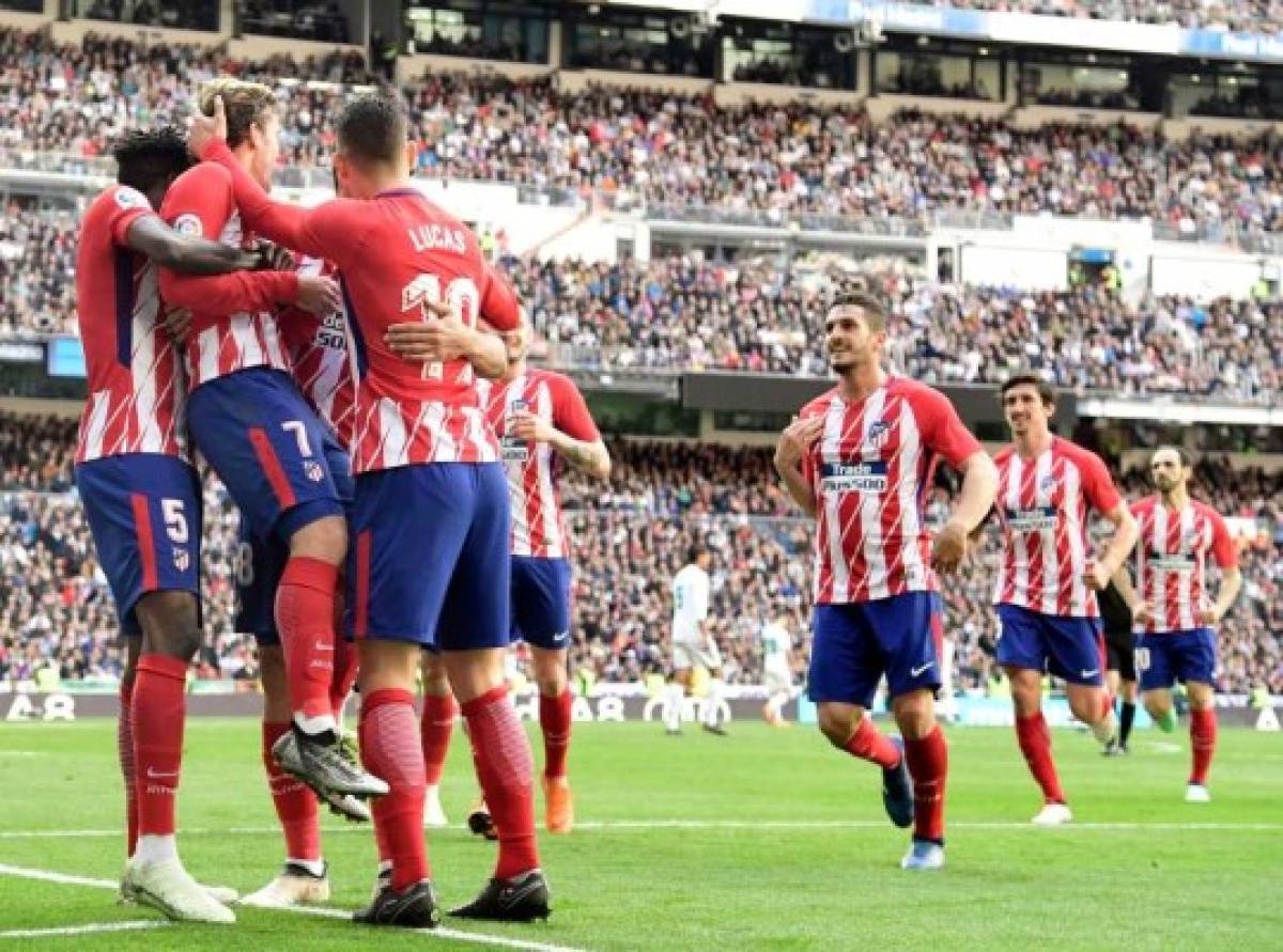 Atletico Madrid's French forward Antoine Griezmann (2L) celebrates a goal with teammates during the Spanish league football match between Real Madrid CF and Club Atletico de Madrid at the Santiago Bernabeu stadium in Madrid on April 8, 2018. / AFP PHOTO / JAVIER SORIANO