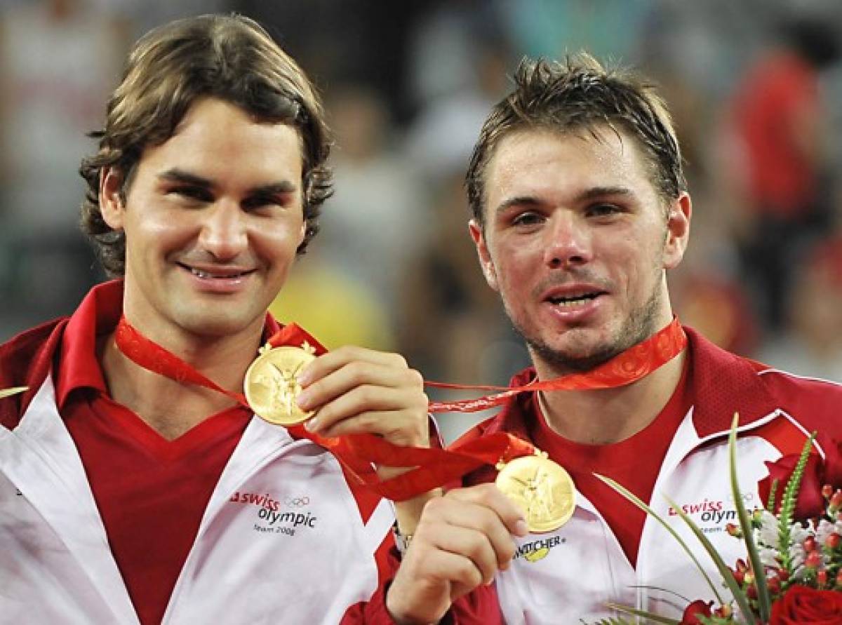 (FILES) In this file photograph taken on August 16, 2008 Roger Federer (L) and Stanislas Wawrinka of Switzerland pose with their gold medals after they won the Olympic gold in the men's double's tennis match against Sweden's Simon Aspelin and Thomas Johansson, at the Olympic Green Tennis Centre in Beijing. - Roger Federer announced on July 13, 2021 he has withdrawn from the upcoming Tokyo Olympics after a 'setback' with his recovery from a knee injury. The 20-time Grand Slam champion was knocked out of Wimbledon in the quarter-finals by Hubert Hurkacz last week. 'During the grass court season, I unfortunately experienced a setback with my knee, and have accepted that I must withdraw from the Tokyo Olympic Games,' Federer said in a statement on social media. (Photo by PHILIPPE HUGUEN / AFP)