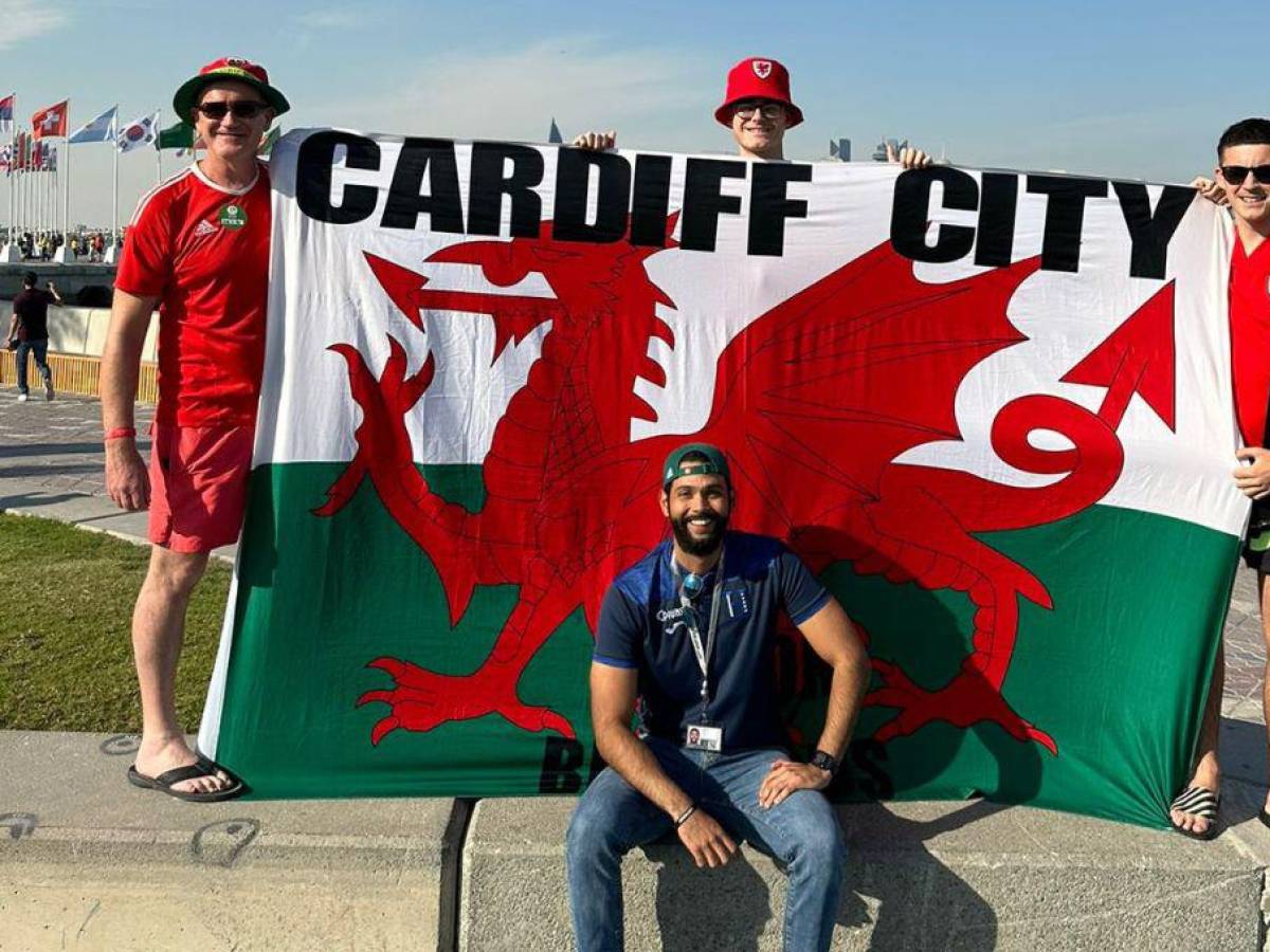 Carlos Flores posando junto con unos galeses que mostraron una bandera de su país