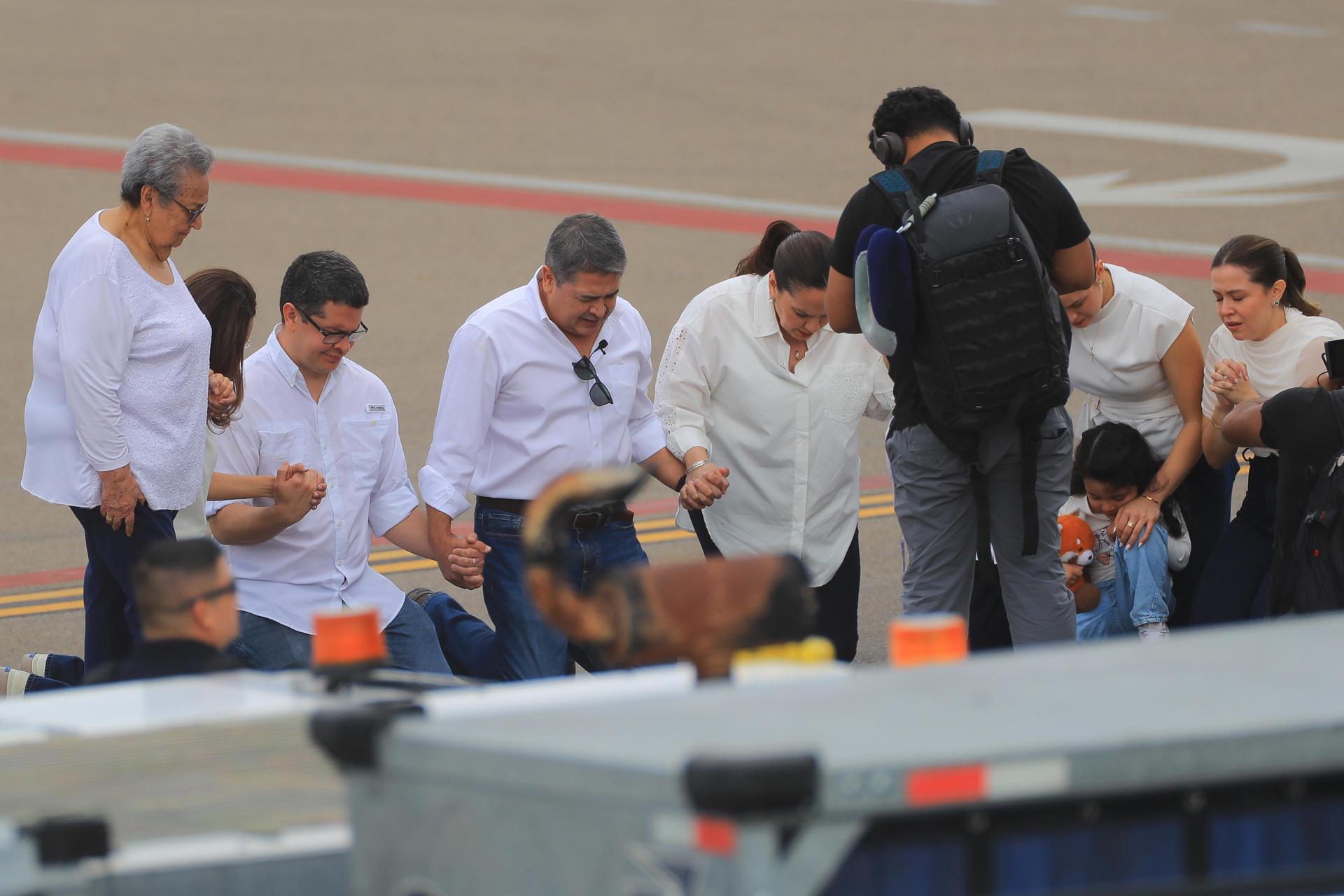 Juan Orlando Hernández y sus familiares se arrodillaron en la pista para realizar una oración.