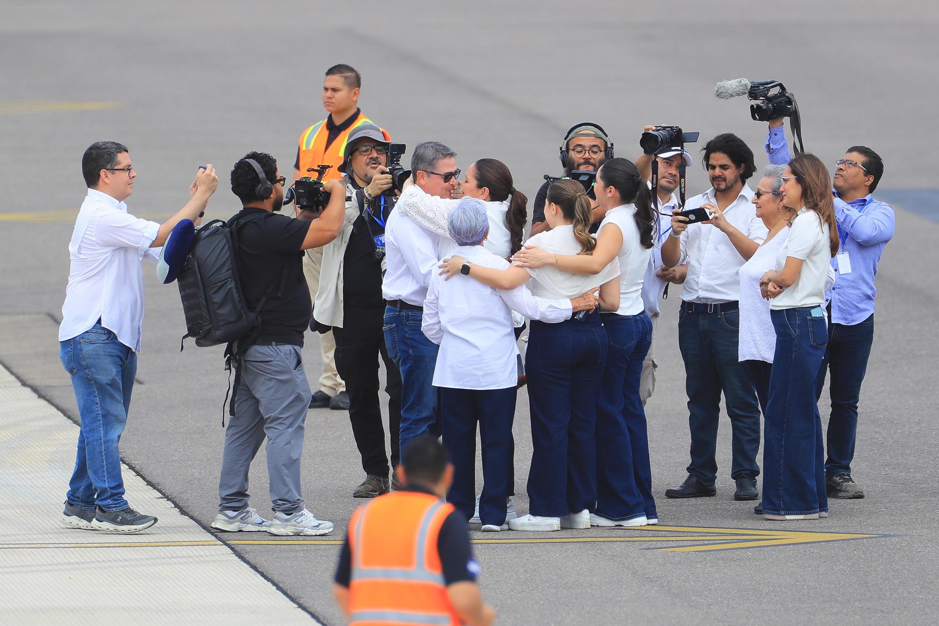 El abrazo de Juan Orlando Hernández y su esposa ante la mirada de su madre, hijos y medios de comunicación.