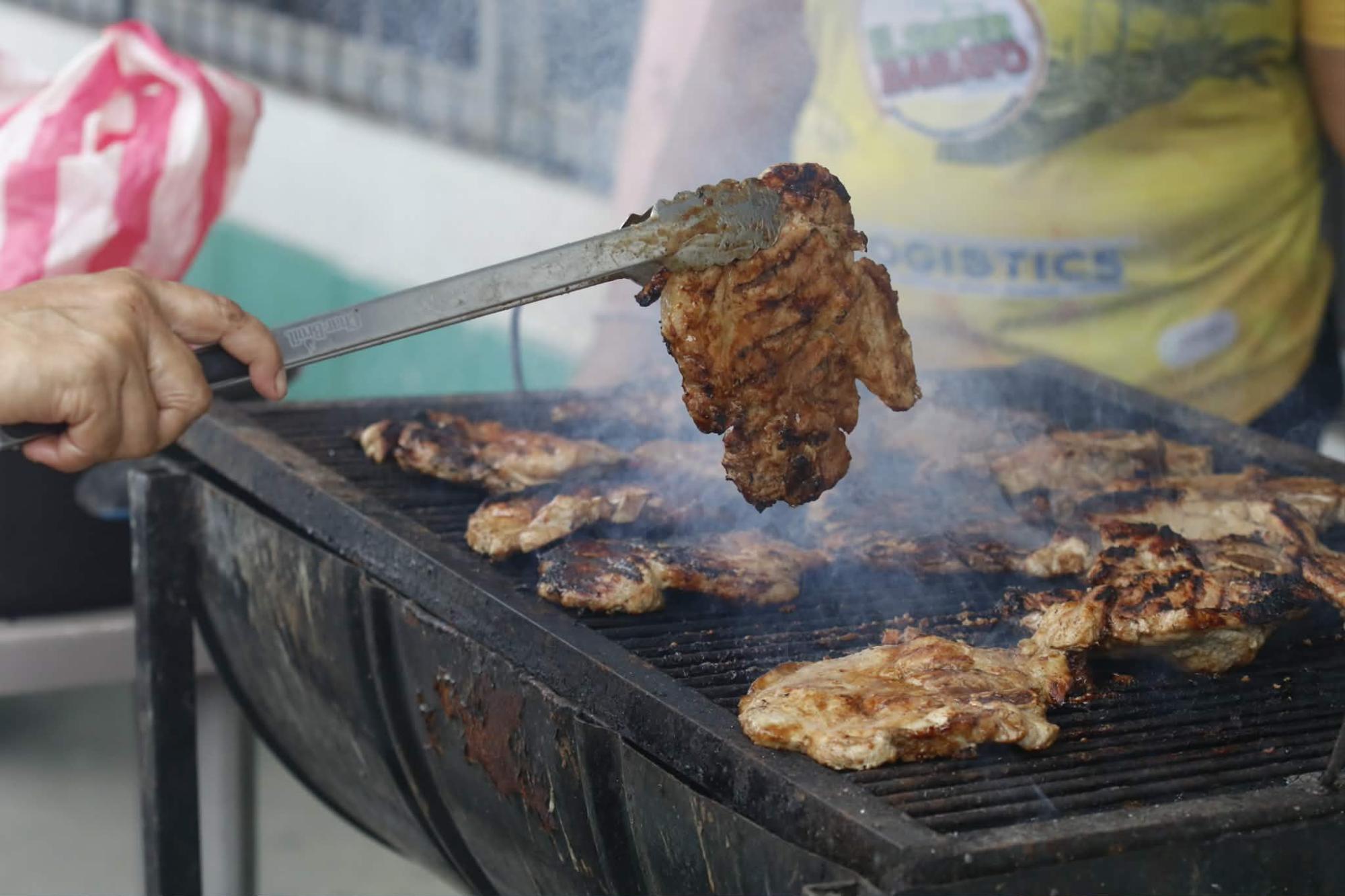Un manjar se cocina frente al estadio Excélsior, la carne y chuletas asadas. Foto Neptelí Romero.