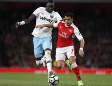 Arsenal's Chilean striker Alexis Sanchez (R) vies with West Ham United's Senegalese midfielder Cheikhou Kouyate during the English Premier League football match between Arsenal and West Ham United at the Emirates Stadium in London on April 5, 2017. Arsenal won the match 3-0. / AFP PHOTO / Ian KINGTON / RESTRICTED TO EDITORIAL USE. No use with unauthorized audio, video, data, fixture lists, club/league logos or 'live' services. Online in-match use limited to 75 images, no video emulation. No use in betting, games or single club/league/player publications. /