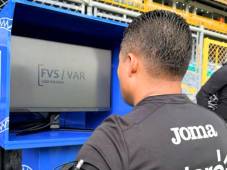 El árbitro Armando Castro revisa el FVS-VAR durante un encuentro del torneo Clausura de la liga hondureña.