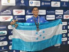 Josué Gabriel Sánchez Rodríguez posa con orgullo con la bandera de Honduras al subirse al podio.