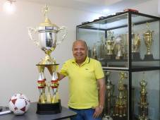 Luis Girón posa con orgullo junto al trofeo de campeón en 2013 que les dio el ascenso a primera división y el balón del juego decisivo que era de Juticalpa, pero se lo guardó por el valor deportivo. Fotos Neptalí Romero.
