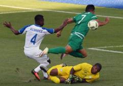 El portero hondureño Luis López salió a jugarse el físico en esta de las primeras jugadas del partido luego que el delantero argelino Baghdad Bounedjah ganara la línea de fondo al defensor Kevin Álvarez. Fotos Agencias