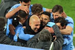 Manchester City's English midfielder Phil Foden (C, hidden) celebrates scoring the 1-2 goal with his team-mates and Manchester City's Spanish manager Pep Guardiola during the UEFA Champions League quarter-final second leg football match between BVB Borussia Dortmund and Manchester City in Dortmund, western Germany, on April 14, 2021. (Photo by WOLFGANG RATTAY / various sources / AFP)
