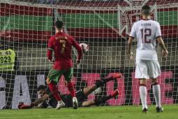 Portugal's forward Cristiano Ronaldo (C) scores a goal during the international friendly football match between Portugal and Qatar at the Algarve stadium in Loule, near Faro, southern Portugal, on October 9, 2021. (Photo by CARLOS COSTA / AFP)