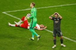 Manchester United's Portuguese midfielder Bruno Fernandes (R) reacts next to Leipzig's Hungarian goalkeeper Peter Gulacsi holding the ball as Leipzig's Hungarian defender Willi Orban lays on the ground during the UEFA Champions League Group H football match RB Leipzig v Manchester United in Leipzig, eastern Germany, on December 8, 2020. (Photo by Odd ANDERSEN / various sources / AFP)