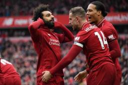 Liverpool's Egyptian midfielder Mohamed Salah (L) celebrates with Liverpool's English midfielder Jordan Henderson (2nd R) and Liverpool's Dutch defender Virgil van Dijk (R) after scoring their second goal during the English Premier League football match between Liverpool and Chelsea at Anfield in Liverpool, north west England on April 14, 2019. (Photo by Paul ELLIS / AFP) / RESTRICTED TO EDITORIAL USE. No use with unauthorized audio, video, data, fixture lists, club/league logos or 'live' services. Online in-match use limited to 120 images. An additional 40 images may be used in extra time. No video emulation. Social media in-match use limited to 120 images. An additional 40 images may be used in extra time. No use in betting publications, games or single club/league/player publications. /