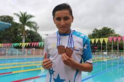 Sebastián Serafeim presume de sus medallas frente al lente después de la premiación.