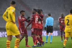 Bayern Munich's German midfielder Leroy Sane (2nd R) celebrates scoring the 2-0 with his team-mates Bayern Munich's French forward Kingsley Coman (L) and Bayern Munich's Canadian midfielder Alphonso Davies (2nd L) during the UEFA Champions League group E football match FC Bayern Munich v FC Barcelona in Munich, southern Germany on December 8, 2021. (Photo by Christof STACHE / AFP)