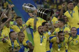 Brazil's Dani Alves (C) and teammates celebrates with the trophy after winning the Copa America after defeating Peru in the final match of the football tournament at Maracana Stadium in Rio de Janeiro, Brazil, on July 7, 2019. (Photo by Juan MABROMATA / AFP)