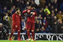Liverpool's German manager Jurgen Klopp (C) embraces Liverpool's Brazilian midfielder Roberto Firmino (R) on the pitch after the English Premier League football match between Brighton and Hove Albion and Liverpool at the American Express Community Stadium in Brighton, southern England on January 12, 2019. - Liverpool won the game 1-0. (Photo by Glyn KIRK / AFP) / RESTRICTED TO EDITORIAL USE. No use with unauthorized audio, video, data, fixture lists, club/league logos or 'live' services. Online in-match use limited to 120 images. An additional 40 images may be used in extra time. No video emulation. Social media in-match use limited to 120 images. An additional 40 images may be used in extra time. No use in betting publications, games or single club/league/player publications. /