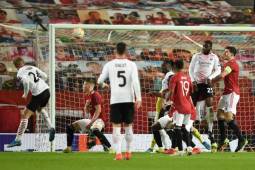 AC Milan's Danish defender Simon Kjaer (L) heads the ball to score their first goal to equalise 1-1 during the UEFA Europa League round of 16 first leg football match between Manchester United and AC Milan at Old Trafford in Manchester, north west England, on March 11, 2021. (Photo by Oli SCARFF / AFP)