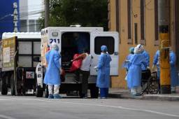 Una persona es ingresada a una ambulancia por miembros del Ministerio de Salud debido a los síntomas que sufría debido al coronavirus. Fotos AFP