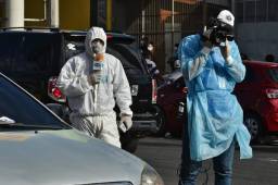 Los medios de comunicación autorizados en Honduras, andan bien protegidos haciendo las coberturas de la pandemia en los hospitales. Fotos AFP