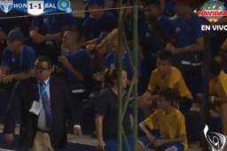 Comisario del partido se acerca a los aficionados de El Salvador para pedirles que guarden silencio.