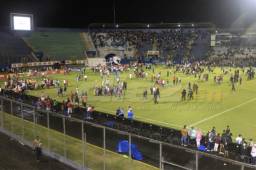 La afición al escuchar y sentir gas lacrimógeno, se metieron a la cancha. Foto Ronald Aceituno.