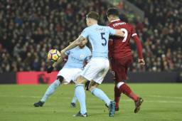 Liverpool's Brazilian midfielder Roberto Firmino (R) chips the ball up to score their second goal to take the lead 2-1 during the English Premier League football match between Liverpool and Manchester City at Anfield in Liverpool, north west England on January 14, 2018. / AFP PHOTO / Oli SCARFF / RESTRICTED TO EDITORIAL USE. No use with unauthorized audio, video, data, fixture lists, club/league logos or 'live' services. Online in-match use limited to 75 images, no video emulation. No use in betting, games or single club/league/player publications. /