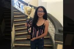 Alejandra Nicolle posando con trofeo del primer lugar de la Federación Nacional de Ajedrez de Honduras que le aseguró el boleto a Rusia.