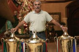 Manuel Keosseián posando con las tres copas de campeón ganadas con Marathón.