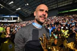 Manchester City's Spanish manager Pep Guardiola shows the Premier League trophy to supporters after their 4-1 victory in the English Premier League football match between Brighton and Hove Albion and Manchester City at the American Express Community Stadium in Brighton, southern England on May 12, 2019. - Manchester City held off a titanic challenge from Liverpool to become the first side in a decade to retain the Premier League on Sunday by coming from behind to beat Brighton 4-1 on Sunday. (Photo by Glyn KIRK / AFP) / RESTRICTED TO EDITORIAL USE. No use with unauthorized audio, video, data, fixture lists, club/league logos or 'live' services. Online in-match use limited to 120 images. An additional 40 images may be used in extra time. No video emulation. Social media in-match use limited to 120 images. An additional 40 images may be used in extra time. No use in betting publications, games or single club/league/player publications. /