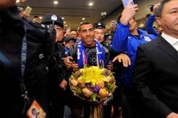 Carlos Tevez fue escoltado por policías entre la multitud que coreó su nombre a su llegada a China. Fotos AFP