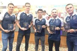 Los jugadores del Motagua, Roberto Moreira, Mathías Galvaliz, Omar Elvir y Denil Maldonado, posando con el libro de los 90 años del ciclón. Fotos cortesía Motagua