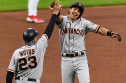 El beisbolista hondureño Mauricio Dubón festeja con el entrenador tercera base Ron Wotus su cuadrangular.