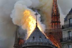 Flames and smoke are seen billowing from the roof at Notre-Dame Cathedral in Paris on April 15, 2019. - A fire broke out at the landmark Notre-Dame Cathedral in central Paris, potentially involving renovation works being carried out at the site, the fire service said.Images posted on social media showed flames and huge clouds of smoke billowing above the roof of the gothic cathedral, the most visited historic monument in Europe. (Photo by LUDOVIC MARIN / AFP)