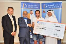 El futbolista posando junto a los representantes del banco catarí.